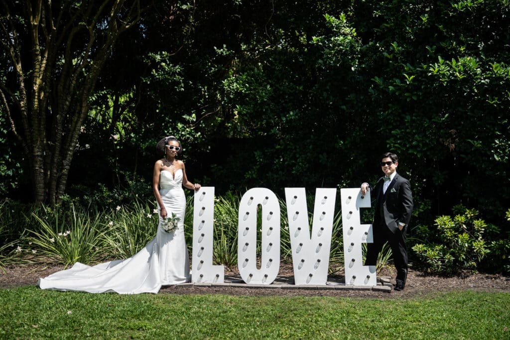 Bride and groom by love sign