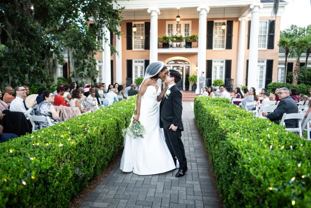 Bride and groom kiss at conclusion of wedding ceremony at Southern Oaks