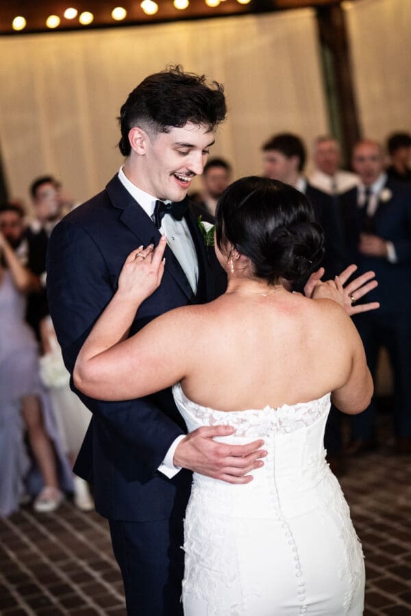 Groom smiles at bride during first dance