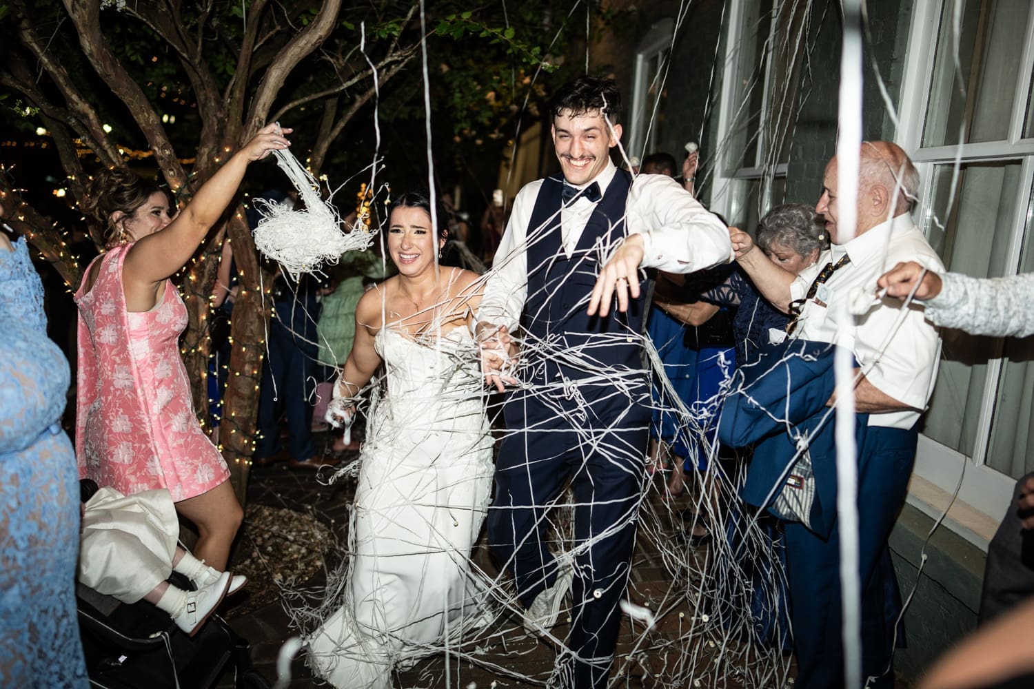 Bride and groom walking through streamers