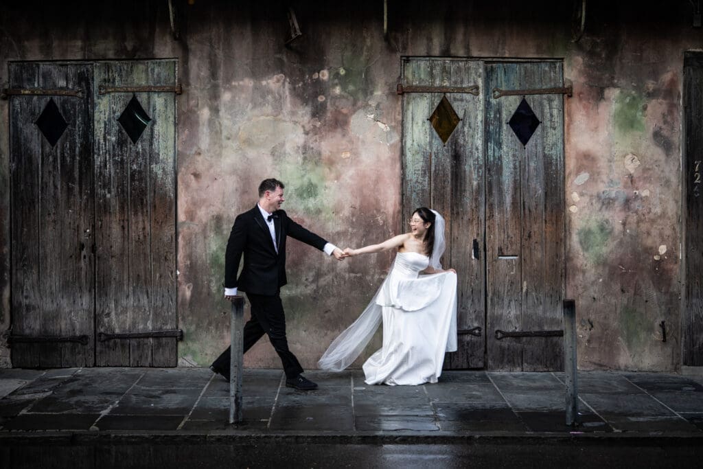 Bride and groom running in front of Preservation Jazz Hall in New Orleans