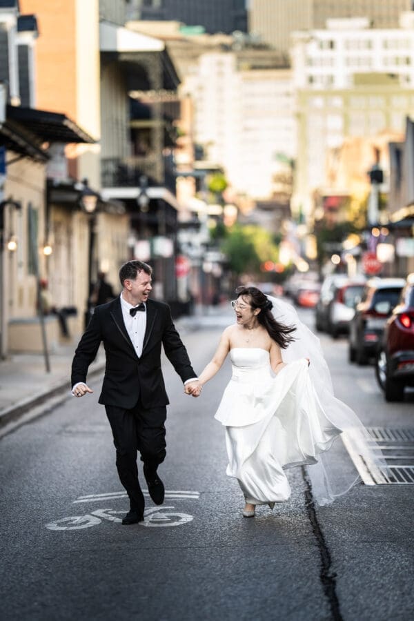 Bride and groom running through the French Quarter