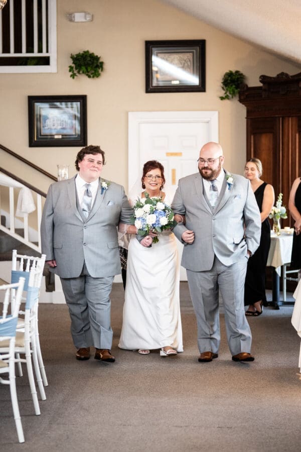 Bride walks up the aisle escorted by her sons