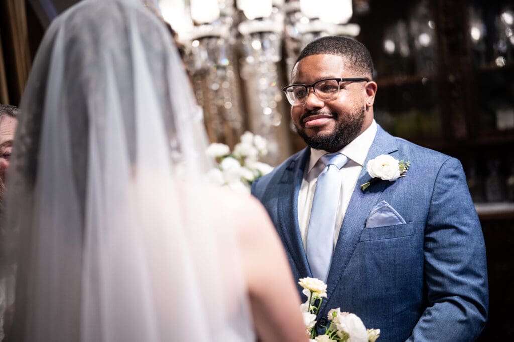 Groom smiles at bride