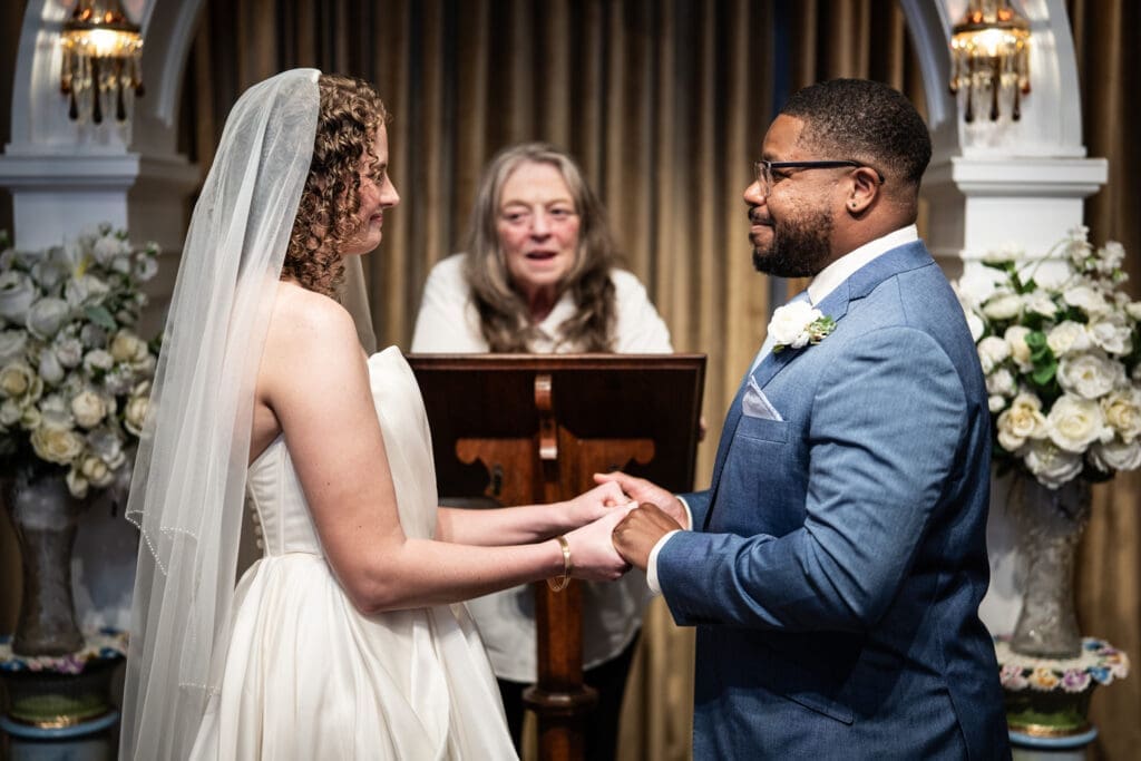 Bride and groom hold hands during elopement ceremony