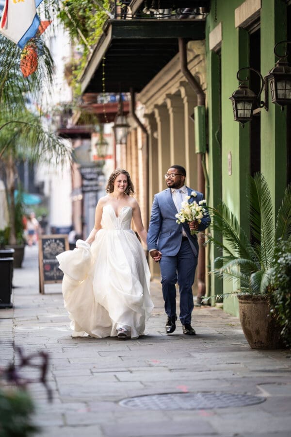 Bride and groom walk down French Quarter alley