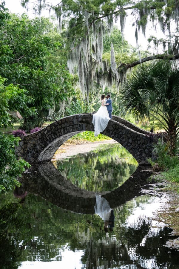 Bride and groom kiss on bridge in City Park