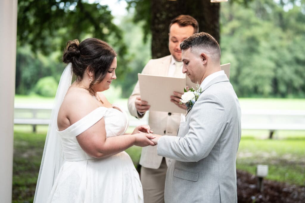 Bride places ring on groom's finger