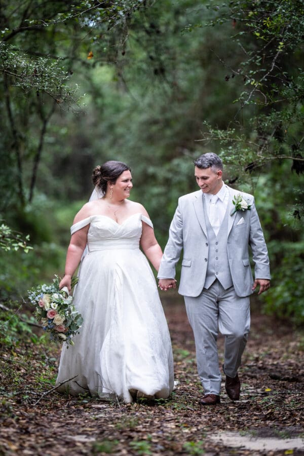 Bride and groom walking through the woods