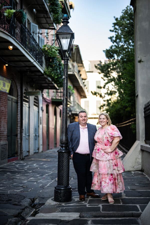 Couple leaning against French Quarter lamp post