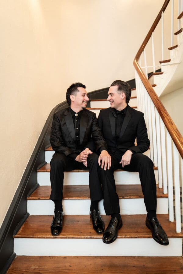 Two grooms sitting on stairs