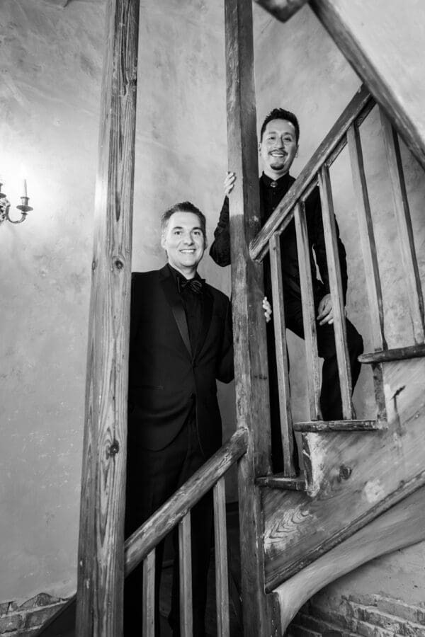 Two grooms on old wooden staircase
