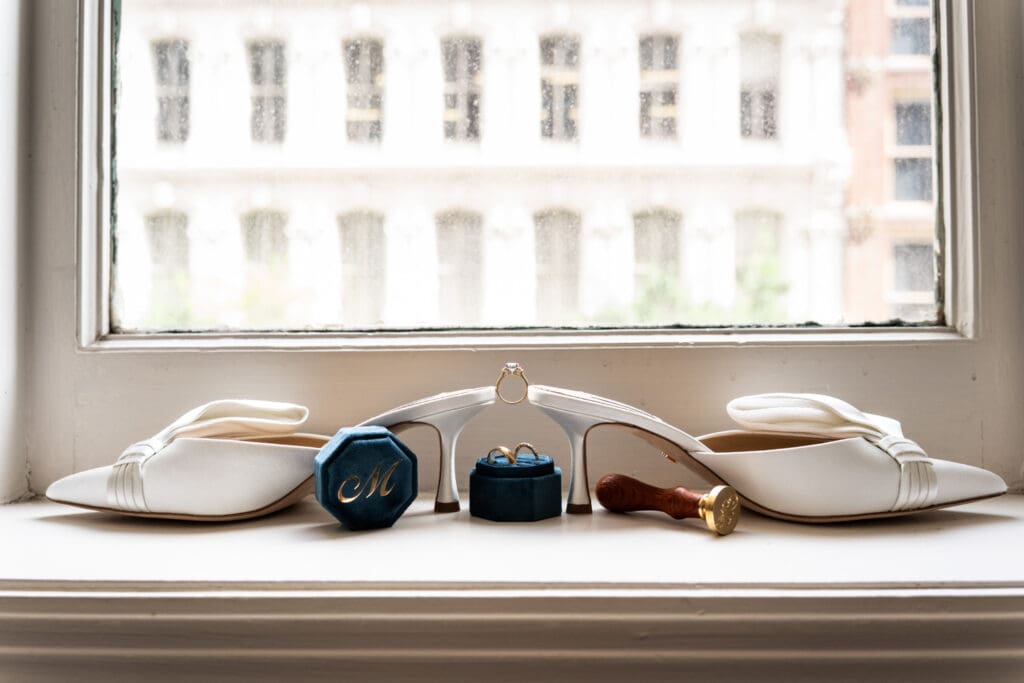 Wedding shoes and rings on window ledge