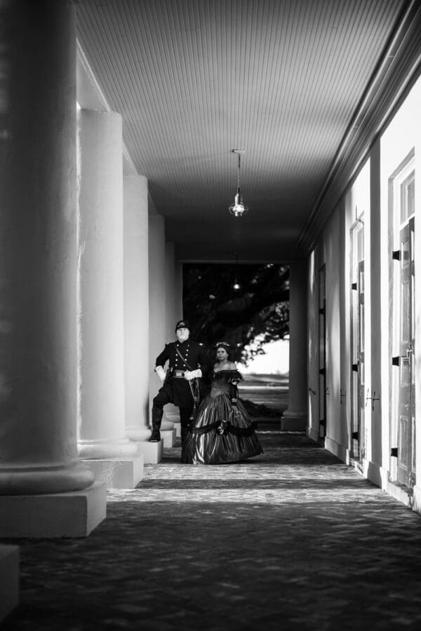 Man and woman in Civil War era attire by columns