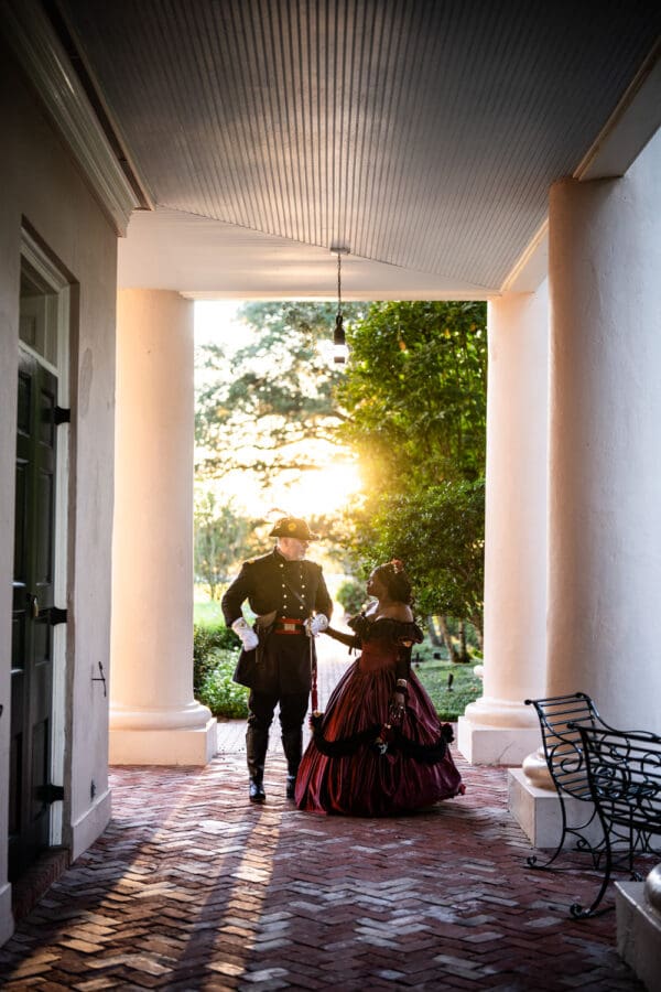Man and woman in Civil War era attire with glowing sun behind them