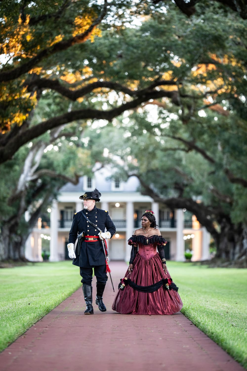 Man and woman in Civil War era attire walking at Oak Alley