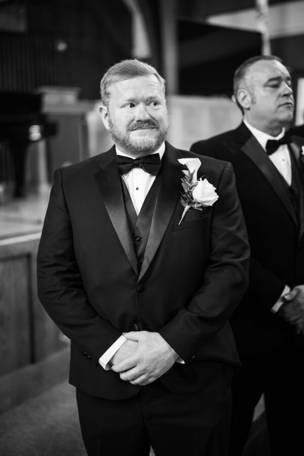 Groom watches bride walk up the aisle