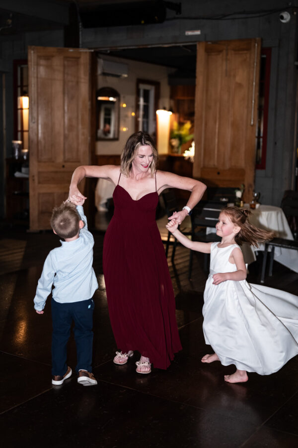 Woman dances with kids at wedding