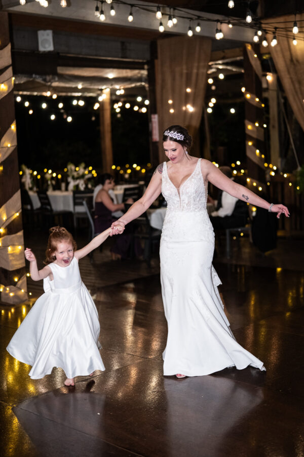 Bride dances with little girl at wedding