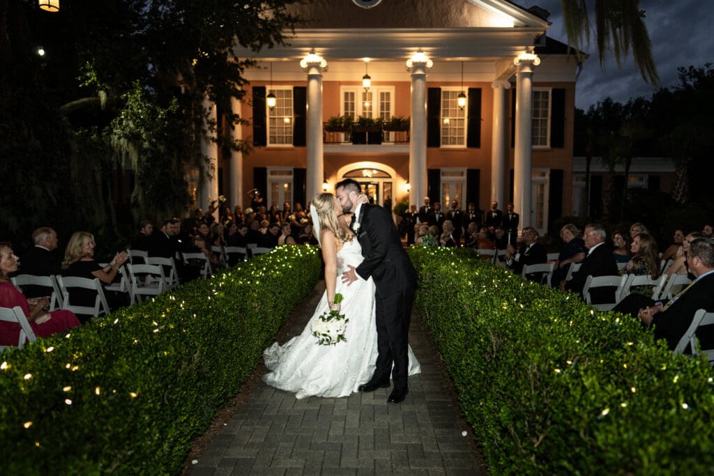 Bride and groom kiss at conclusion of wedding ceremony at Southern Oaks