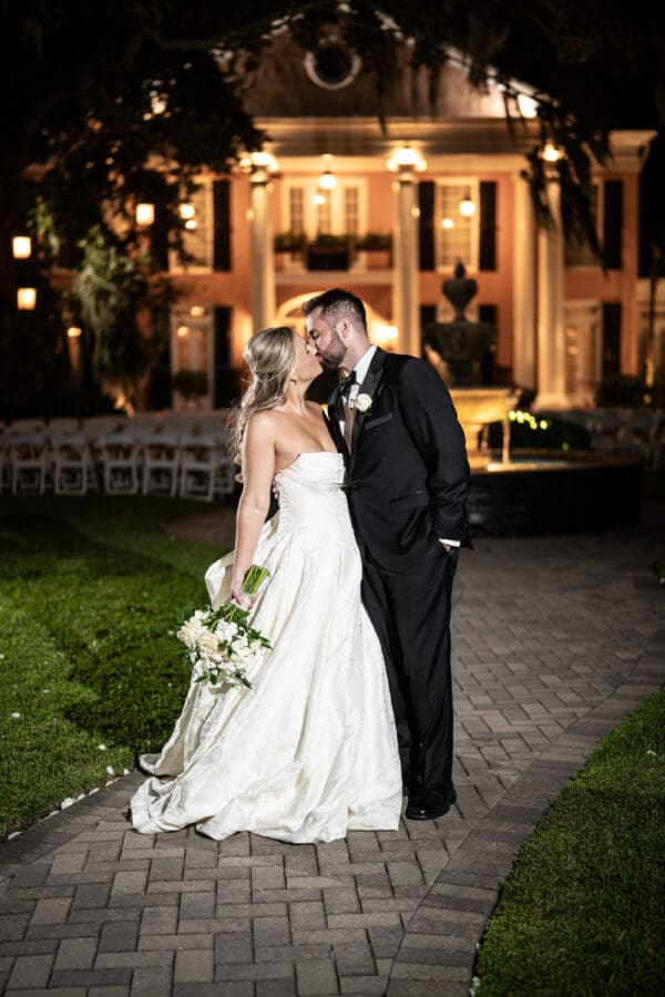 Bride and groom kiss in front of Southern Oaks